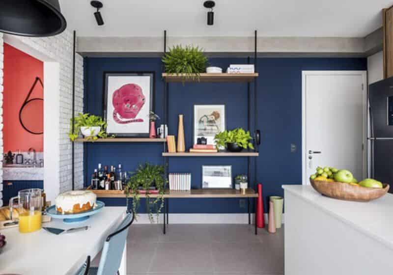 Cozinha pequena decorada com estante, plantas e parede azul.