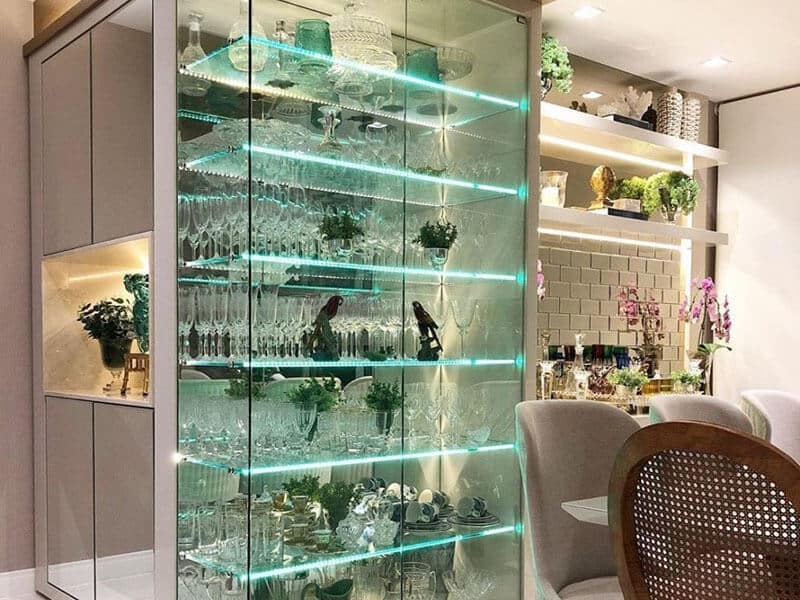 cristaleira de vidro com LED com taças e decorações dentro