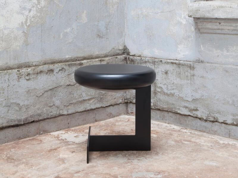 Banco BO preto fotografado em uma parede acimentada