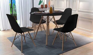 cadeira eames preta pé palito com mesa eames preta pé palito exposta em um tapete cinza felpudo