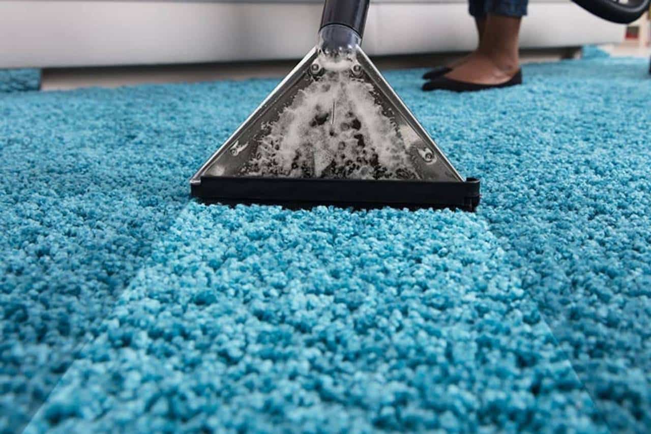 aparelho eletrônico retirando o excesso de produto em um tapete azul