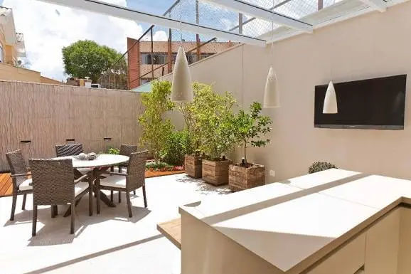 área externa com parede na cor creme e outros detalhes de decoração