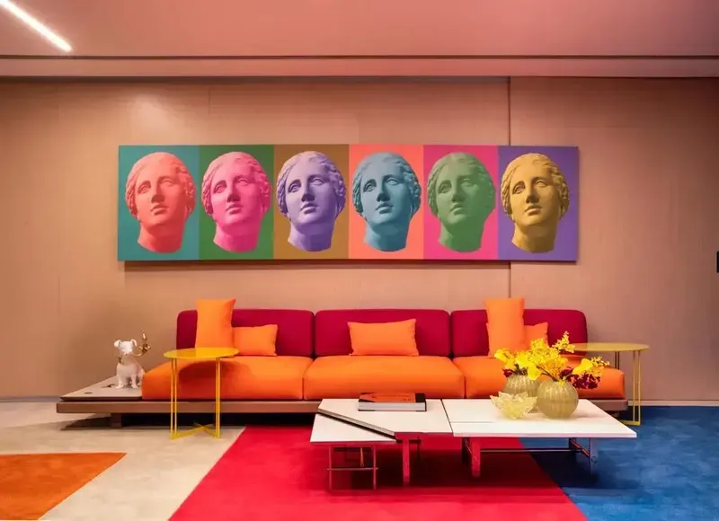 sala decorada com o estilo dopamine com sofá laranja e quadro colorido