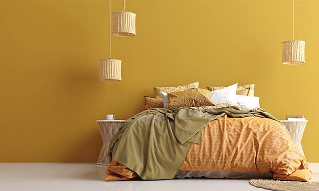 quarto de casal decorado com tons de mostarda e bege