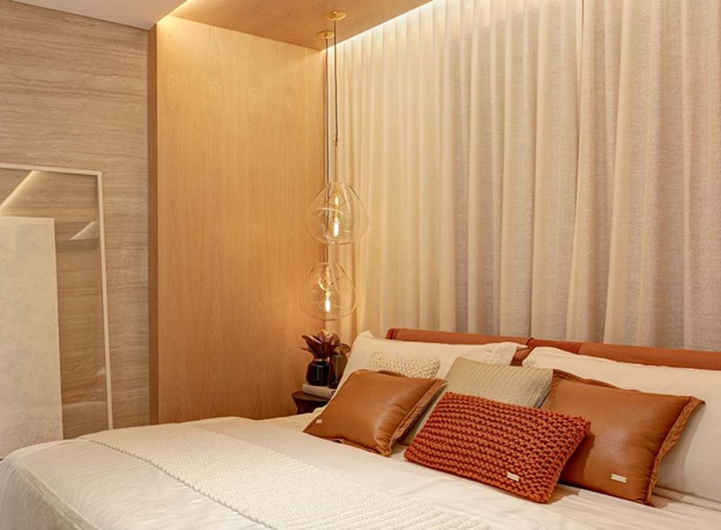 quarto de casal decorado com travesseiros e almofadas em tons terrosos