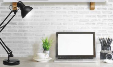 tipos de luminárias de mesa: modelo reclinável ao lado de um computador