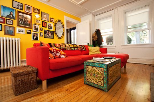 parede amarela com sofá vermelho