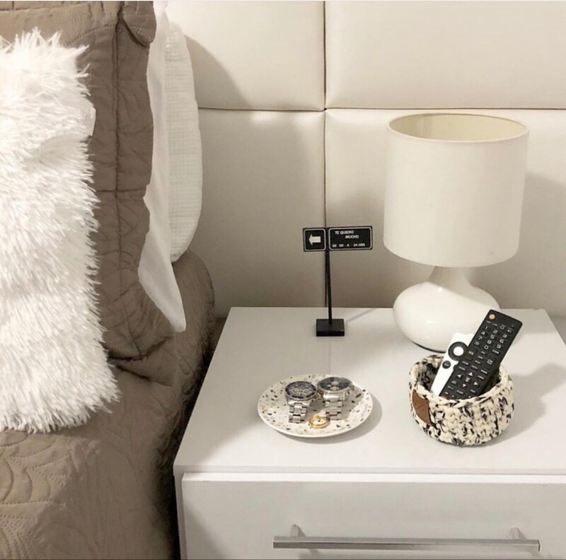 Mesa de cabeceira com abajur e objetos decorativos