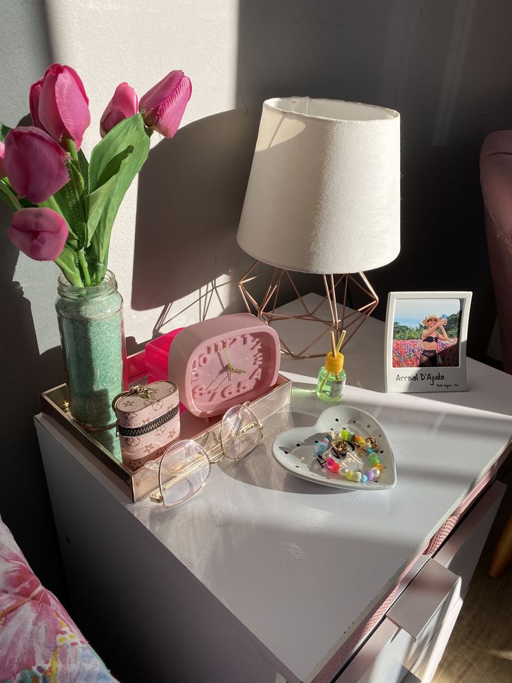 Mesa de cabeceira decorada com flores e objetos variados.