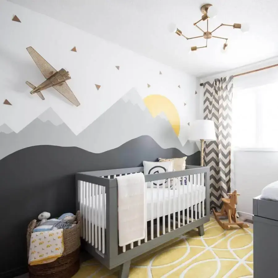 Quarto infantil com berço e decoração de montanhas