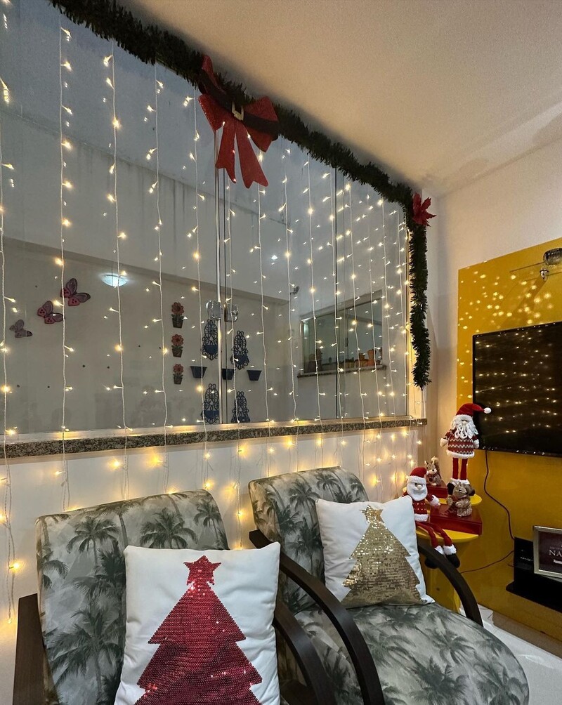 Decoração natalina com luzes e almofadas festivas.