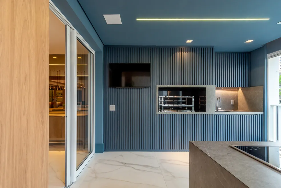 Cozinha moderna com parede azul e iluminação