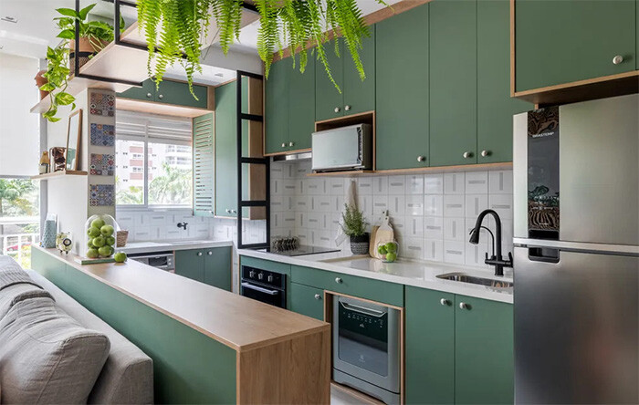 Cozinha moderna com armários verdes e elementos naturais.