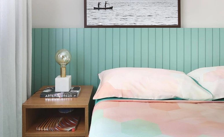 Quarto moderno com cabeceira verde e decoração minimalista