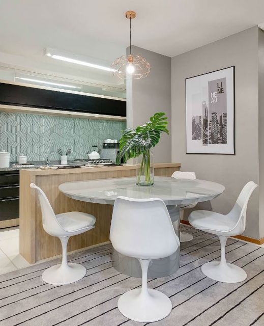 Mesa de jantar moderna com cadeiras brancas em ambiente estiloso.
