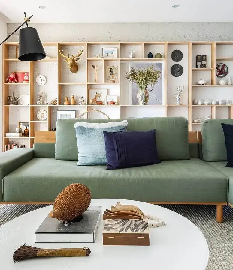 Sala de estar moderna com sofá verde e prateleira decorada
